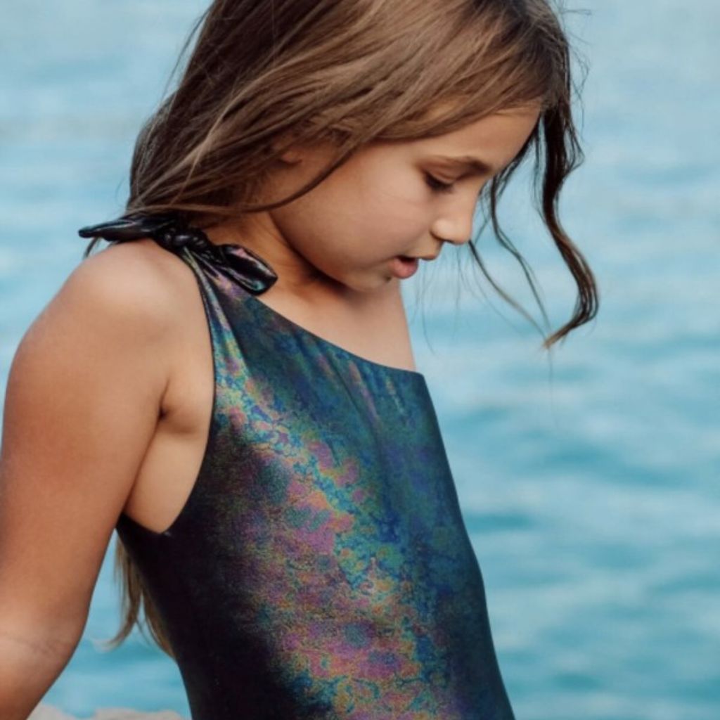 Little girl wearing the Lison Paris disco one shoulder swimsuit