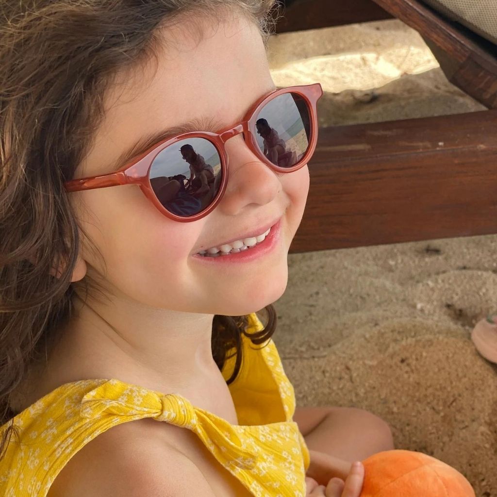 Little girl wearing Maison Juli Julo sunglasses in orange