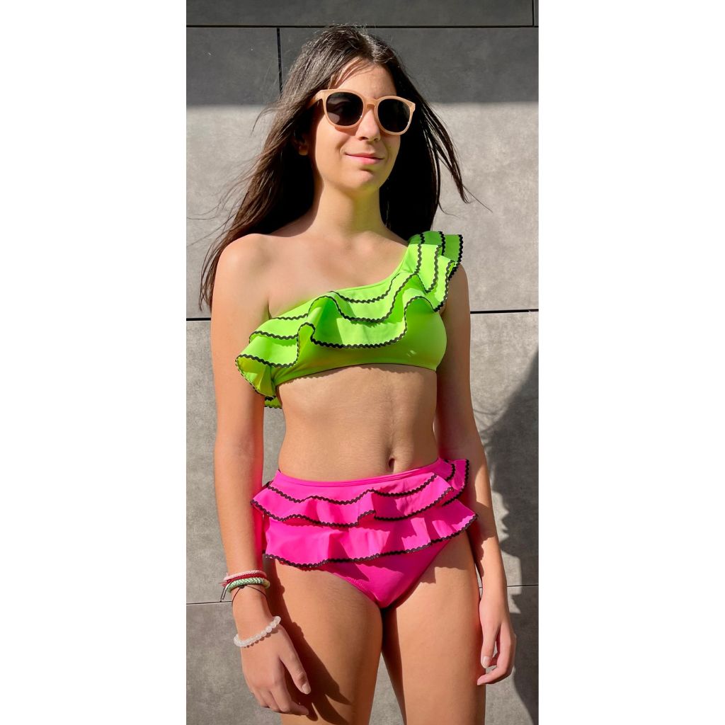 Girl wearing sunglasses wearing Nessi Byrd Kids Momo Two Piece Bikini in Neon Green and Neon Pink with ric rac trim