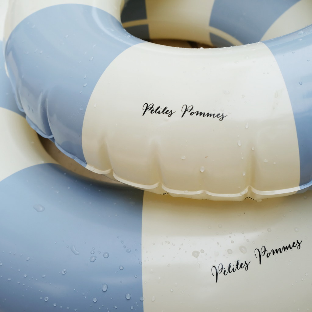 Stack of Petites Pommes inflatable rubber ring floats in Nordic Blue