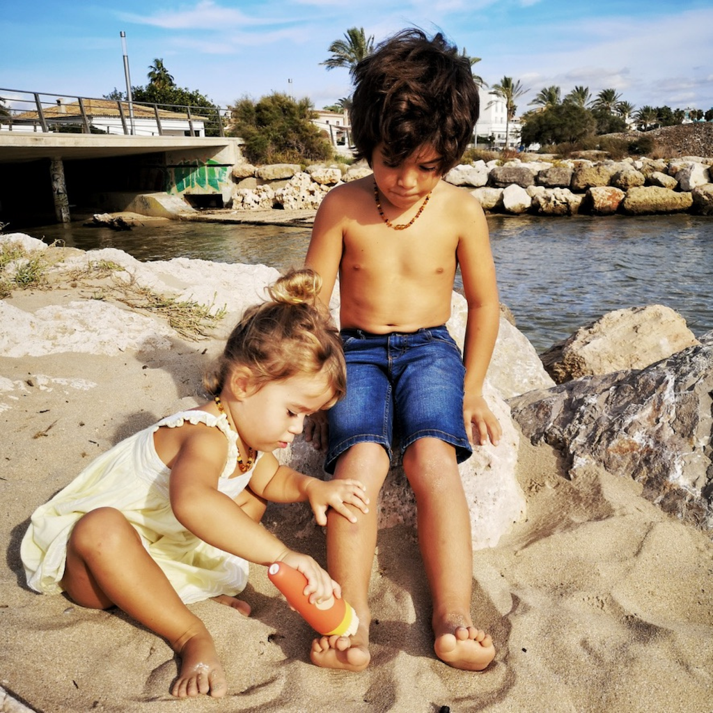 Girl and Boy on the beach removing sand using the SavviSand Sand Removal Applicator