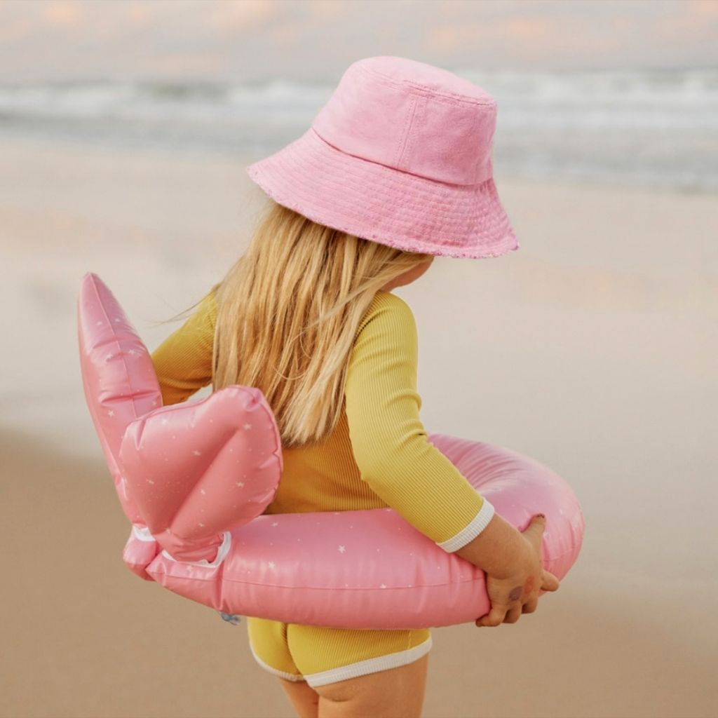 Little girl wearing Sunnylife kiddy pool ring in ocean treasure rose