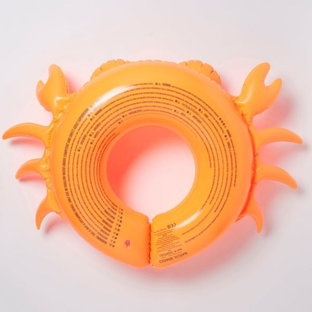 Bottom of the Sunnylife kiddy pool ring in sonny the sea creature neon orange showing the safety information