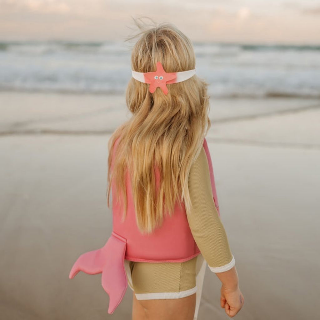 Little girl from the back wearing Sunnylife Kids mini swim goggles in ocean treasure rose with starfish
