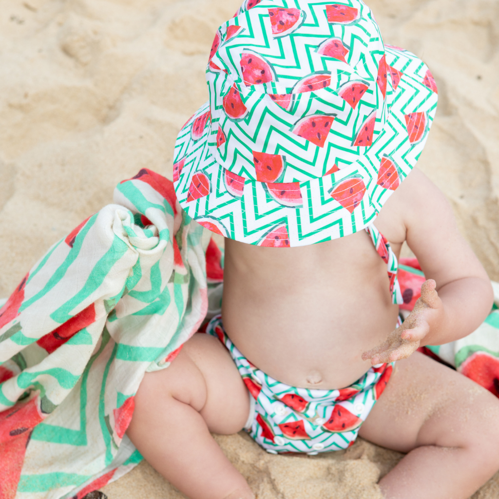 Little baby wearing Anchor & Arrow Frolicking Watermelon print unisex reusable swim hat and swim nappy